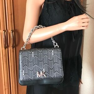 Michael Kors black leather bag with silver tone logo & design. Like new.